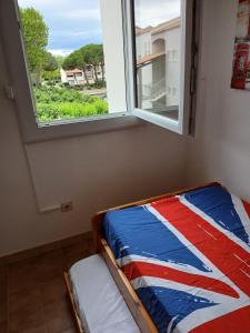a bed in a room with a window at Appartement 2 chambres dans la marina in Saint-Cyprien-Plage
