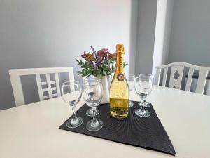 eine Flasche Champagner auf einem Tisch mit Weingläsern in der Unterkunft Adalina Holiday Apartament- Paralia Beach in Paralia Katerinis