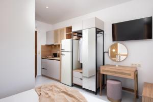 a kitchen with a refrigerator and a table with a mirror at Opalium Beach Front Suites in Potos