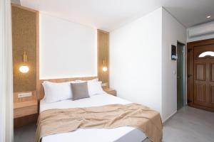 a bedroom with a large bed with white sheets at Opalium Beach Front Suites in Potos