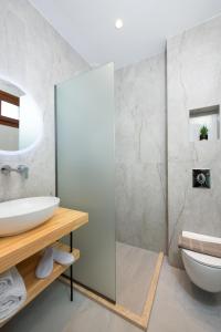 a bathroom with a sink and a toilet at Opalium Beach Front Suites in Potos