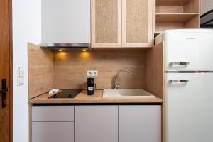 a small kitchen with a sink and a refrigerator at Opalium Beach Front Suites in Potos