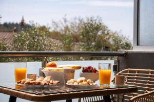 a table with breakfast foods and drinks on a balcony at Opalium Beach Front Suites in Potos