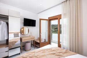 a bedroom with a bed and a desk with a mirror at Opalium Beach Front Suites in Potos