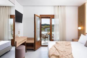 a bedroom with a bed and a desk and a table at Opalium Beach Front Suites in Potos