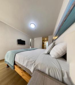 a bedroom with a large white bed and a flat screen tv at Urbano Apartments in Lima
