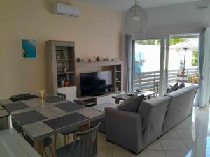 a living room with a table and a television at The Getaway in Agia Marina Nea Kydonias