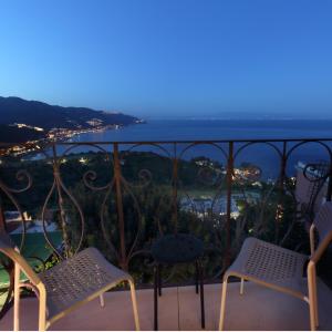 a balcony with chairs and a view of the ocean at Villa Astoria in Taormina