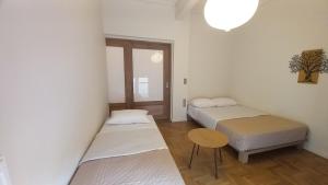 a room with two beds and a table in it at Harmonia Appartment in Trikala in Tríkala