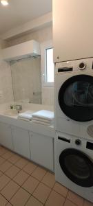 a bathroom with a washing machine and a sink at Le Cézembre - vue 180 baie St Malo in Saint Malo