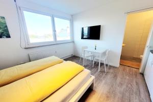 a bedroom with a yellow bed and a table at Mini Sun in Dornbirn