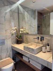 a bathroom with a sink and a toilet at Armonia Apartment in Pefkohori +12 photos