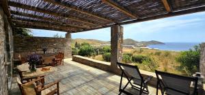a patio with a table and chairs and the ocean at Serifos Rock Villa in Serifos Chora