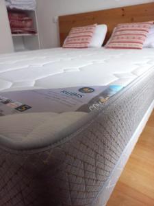 a white bed with two pillows on top of it at Appartement Reines des Pyrénées, T2, entier, centre Luchon, tarif cure thermale, wifi, casier à skis, ascenseur in Luchon