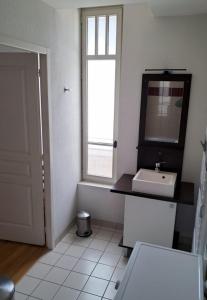 a white bathroom with a sink and a window at Appartement Reines des Pyrénées, T2, entier, centre Luchon, tarif cure thermale, wifi, casier à skis, ascenseur in Luchon