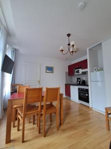 a kitchen and dining room with a table and chairs at Appartement Reines des Pyrénées, T2, entier, centre Luchon, tarif cure thermale, wifi, casier à skis, ascenseur in Luchon