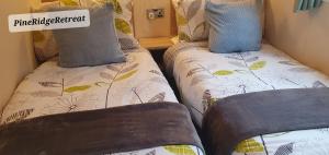 a couple of beds in a small room at Pine Ridge Retreat With FREE GOLF and Air Conditioning in Morpeth