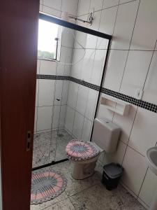 a bathroom with a toilet and a glass shower at Soninho Bão in Cunha