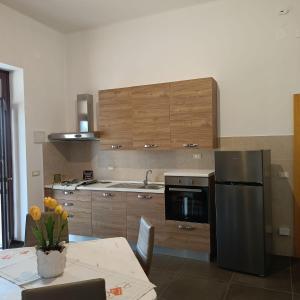 a kitchen with a stainless steel refrigerator and a table at VILLA LISI in Selva di Fasano