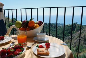 a table with a plate of food and a bowl of fruit at Agunì Agriturismo e Locanda in Palizzi