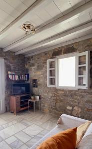 a living room with a stone wall and a couch at Serifos Rock Villa in Serifos Chora