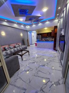 ein Wohnzimmer mit Marmorboden und einem TV in der Unterkunft فيلا جميل جداا in Dawwār Abū Maḩrūs