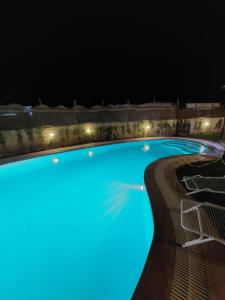 ein Schwimmbad in der Nacht mit Beleuchtung in der Unterkunft فيلا جميل جداا in Dawwār Abū Maḩrūs