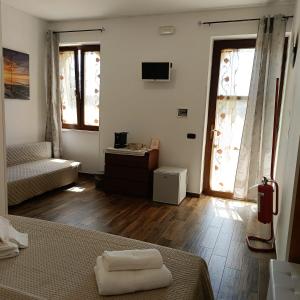 a bedroom with a bed and a couch and wooden floors at VILLA LISI in Selva di Fasano