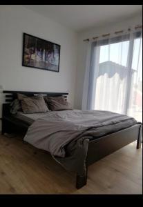 Una cama grande en un dormitorio con ventana. en Maison cosy proche forêt, en Saint-Vincent-de-Paul 7 fotos más