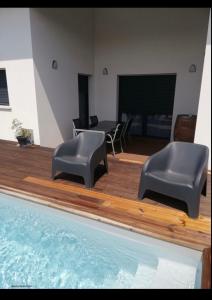 Una sala de estar con dos sillas y un televisor de pantalla grande. en Maison cosy proche forêt, en Saint-Vincent-de-Paul