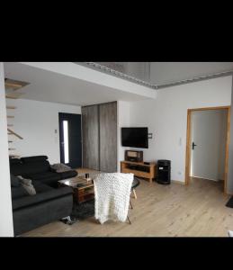 una sala de estar con un sofá y una mesa en Maison cosy proche forêt, en Saint-Vincent-de-Paul