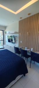 ein Schlafzimmer mit einem Bett, einem Tisch und Stühlen in der Unterkunft Flat Makia Beach Muro Alto, Porto de Galinhas in Ipojuca