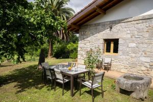 une table et des chaises devant une maison en pierre dans l'établissement Tanbolin, à Gautegiz Arteaga