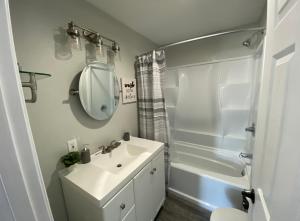 a bathroom with a sink and a mirror and a tub at Blue Mountain Retreat in Elgin