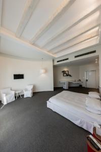 a bedroom with a large white bed and two chairs at Miramar Hotel Resort and Spa in Trâblous +54 photos