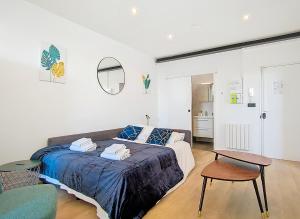 a bedroom with a bed and a table and a chair at Suite Evasion - Bel Appartement in Argenteuil