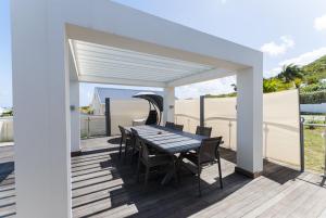 a patio with a table and chairs on a deck at Villa Lalabay in Cul de Sac