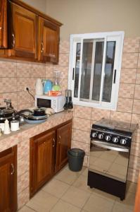 a kitchen with wooden cabinets and a stove top oven at ACNELA Residence Kribi Cameroon in Kribi