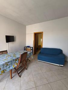 Un dormitorio con una cama azul y una mesa. en casavacanza la vite, en Alezio