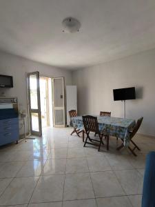 a living room with a table and chairs and a television at casavacanza la vite in Alezio +4 photos