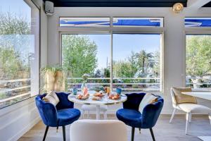 a dining room with blue chairs and a table and windows at Hotel Espadon bleu in Le Lavandou +109 photos