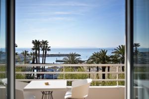a view of the ocean from a balcony with a table and chairs at Hotel Espadon bleu in Le Lavandou