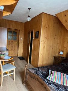 a bedroom with a bed and a wooden wall at Pokoje u Walkoszów in Ząb