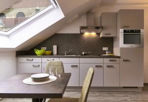 a kitchen with a table and chairs and a window at Gästehaus Stiftsstadt - urban lifestyle Kempten by Hotel Peterhof in Kempten +13 photos