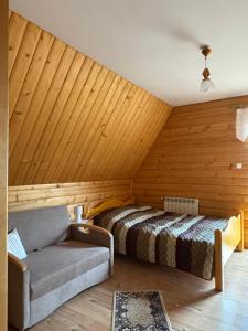 a bedroom with a bed and a couch in a room at Pokoje u Walkoszów in Ząb +5 photos
