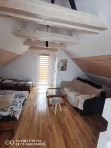 a living room with two beds and a table at Apartament na Dziole in Lipnica Wielka