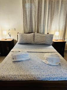 a bed with two white towels on top of it at Dona's Villa Coastal House in Pamunugama in Negombo +21 photos