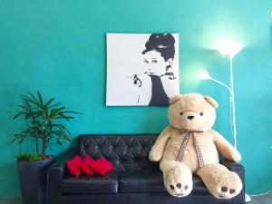 a teddy bear sitting on a couch in a living room at Story Inn City in Hualien City