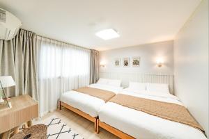 a bedroom with two beds and a window at Sunny Stay Inn in Seoul