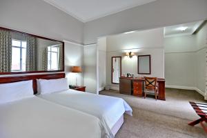 ein Schlafzimmer mit einem großen Bett und einem Schreibtisch in der Unterkunft The Balmoral - Halaal in Durban + 51 Fotos